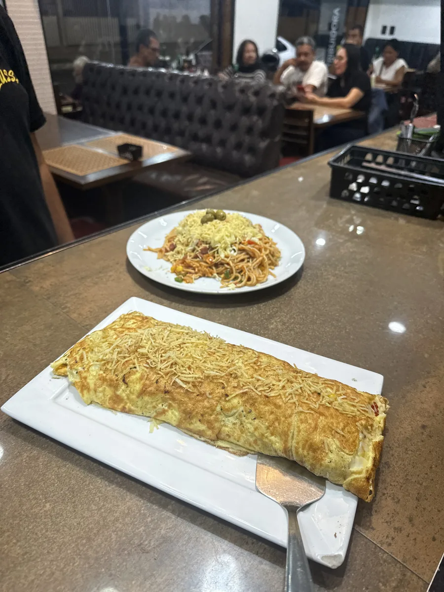 Omelete recheado da Lussan na travessa, coberto de batata palha.